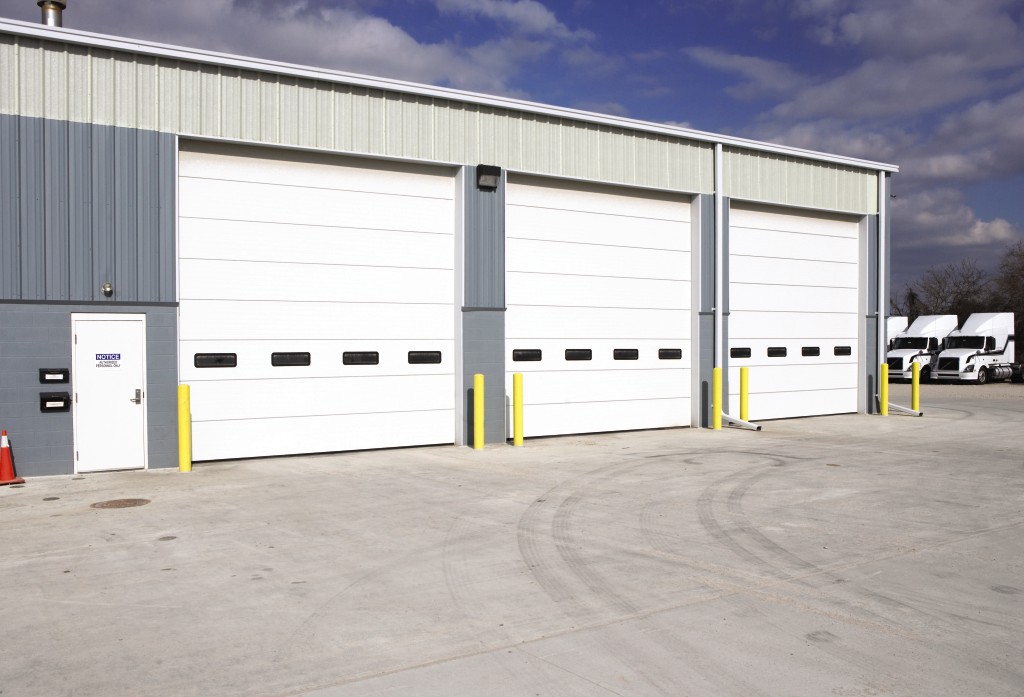 Wayne-Dalton 216 Commercial Sectional Doors on a large commercial warehouse building with semi trucks parked in the background