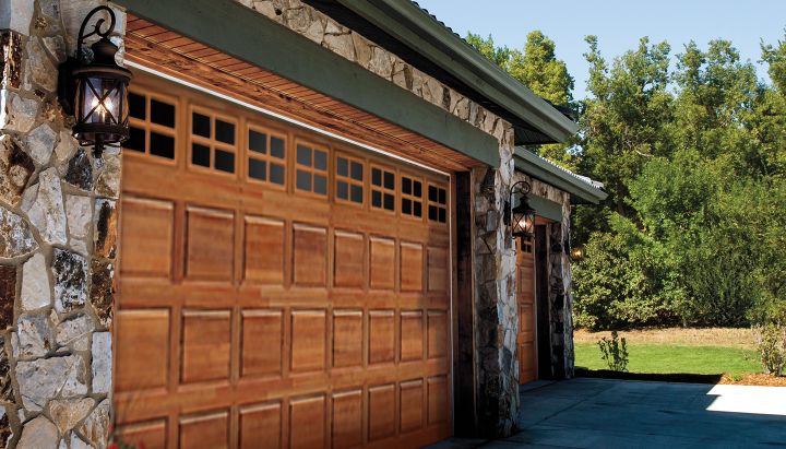 two brown garage doors on a large stone decorated home