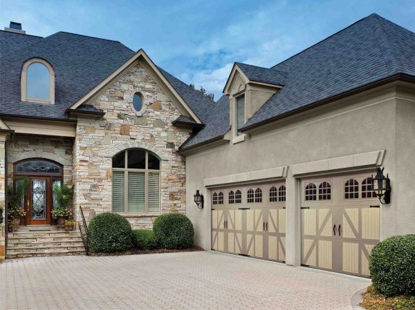 large stone home in san antonio with two garage doors that are different sizes