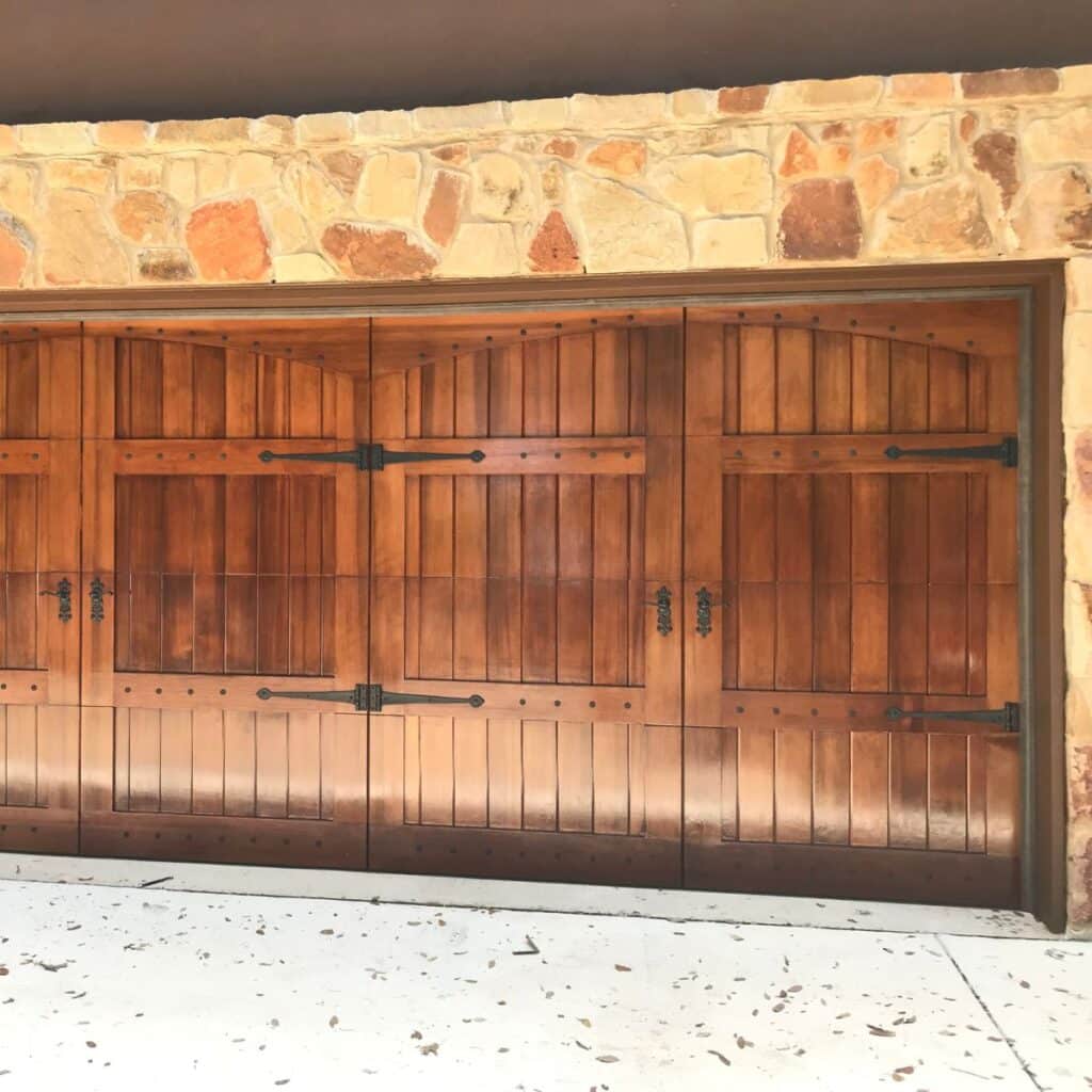 custom decorative brown garage door on a stone home