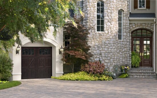 large stone home in san antonio with a dark brown faux wood grain style residential garage door with eight long paneled windows on the top row