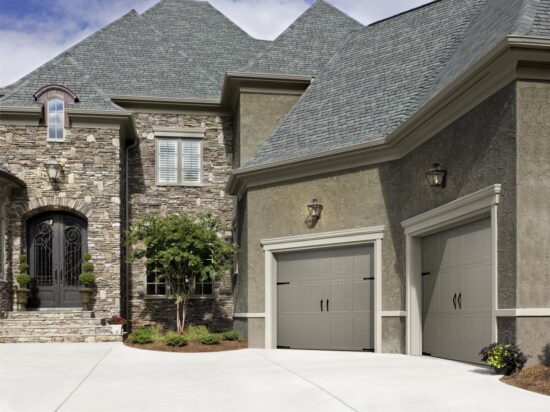 large brown/grey home in san antonio with two grey amarr classica, carriage style residential garage doors with black features