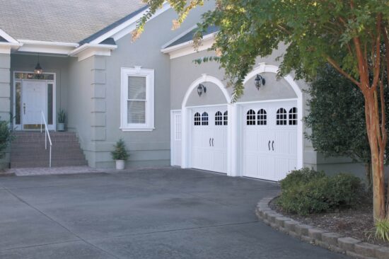 san antonio home with two faux wood grain style residential garage doors