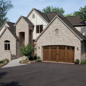 large stone home in san antonio with a clopay canyon ridge, faux wood grain style residential garage door