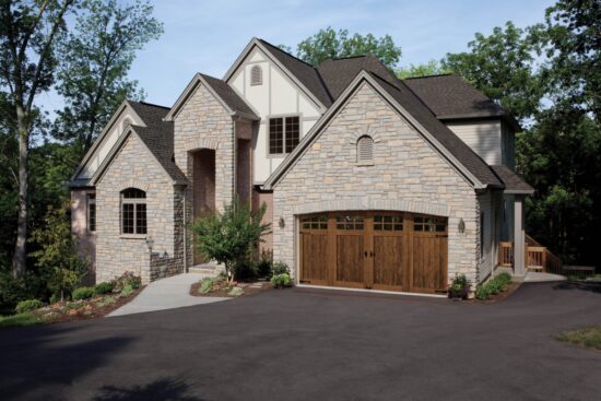 large stone home in san antonio with a clopay canyon ridge, faux wood grain style residential garage door