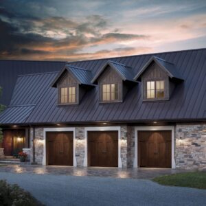 large home at dusk with three clopay canyon ridge, faux wood grain style residential garage doors