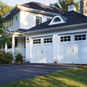 all white home with two clopay canyon ridge, faux wood grain style residential garage doors