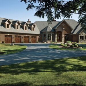 larage home with four clopay canyon ridge, faux wood grain style residential garage doors