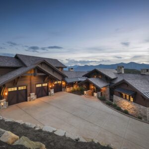 large home at dusk with three clopay canyon ridge, faux wood grain style residential garage doors