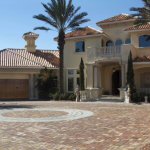 large home with tiled roof and large colums that has a clopay canyon ridge, faux wood grain style residential garage door