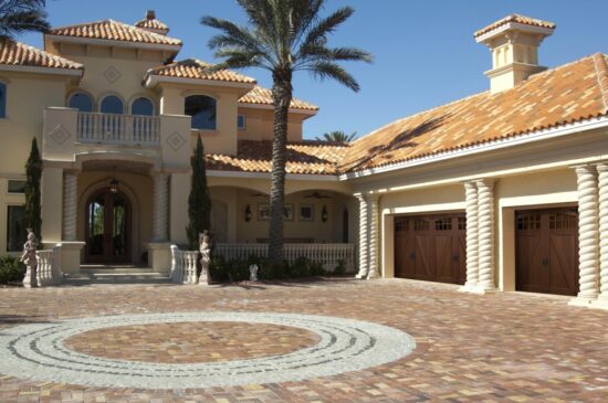spanish style home in san antonio with two clopay canyon ridge, faux wood grain style residential garage doors