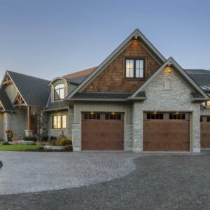 large home with three clopay gallery, faux wood grain style, residential garage door with vertical windows on the top row