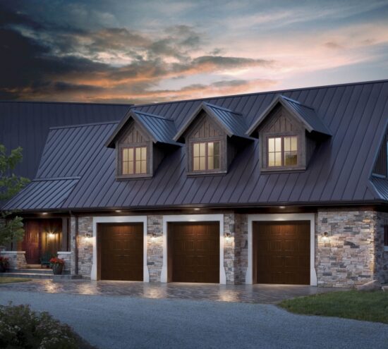 large home at dusk with three dark brown clopay gallery, faux wood grain style, residential garage doors