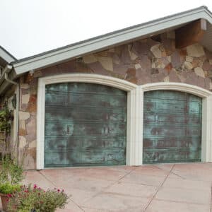 intersting home with green front door and three martin elite copper, modern style residential garage doors with a teal wash to them