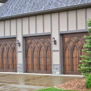 closeup of three garage doors that are custom wood with arched pieces on them to create a depth