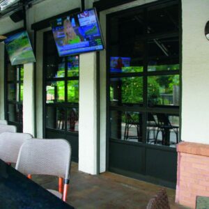 large commercial aluminum full-view door on a commercial building with outdoor seating and televisions