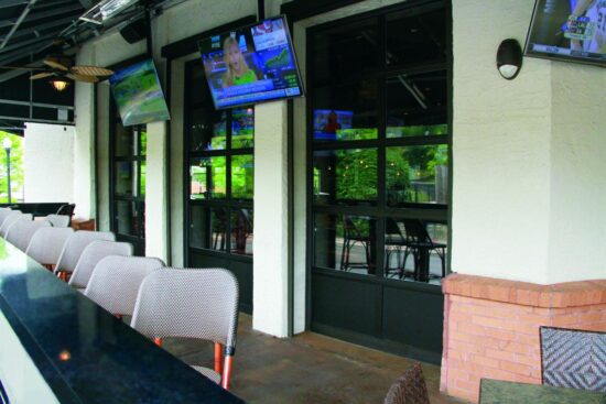 large commercial aluminum full-view door on a commercial building with outdoor seating and televisions