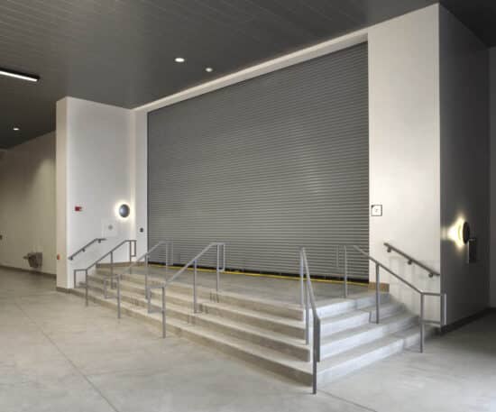large commercial rolling fire garage door on top of steps in a commercial building