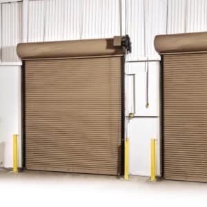 two brown commercial rolling fire garage door side by side in a warehouse setting