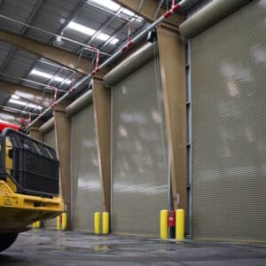 large and tall commercial rolling garage doors in a warehouse setting with a work truck in the foreground