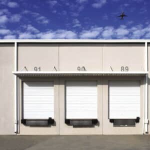 commercial sectional overhead door on a warehouse building with multiple doors