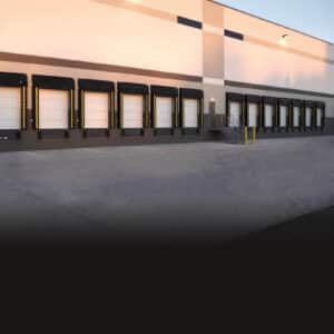 multiple commercial garage doors on a warehouse building