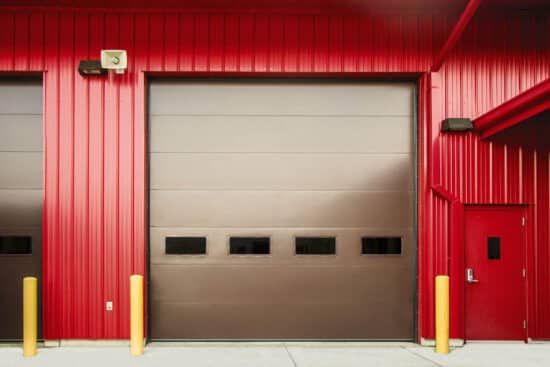 brown commercial garage door on a very red warehouse building