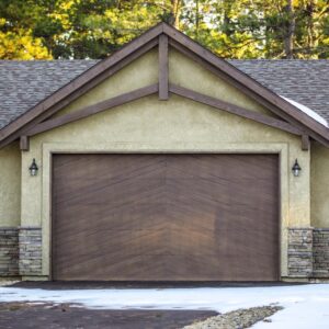 residential home with a custom wood garage door surrounded by snow on the ground