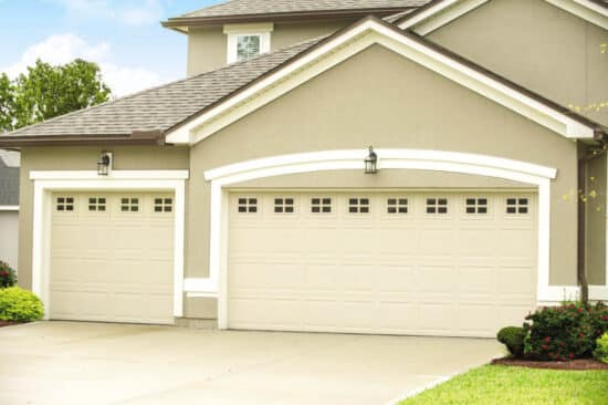 two cream colored traditional style, colonial/ranch raised panel garage doors