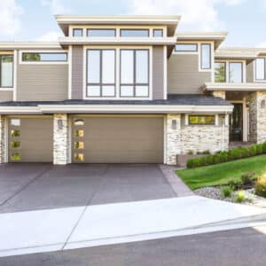 large residential modern home with modern style, flush contemporary panel garage doors with windows on the left side