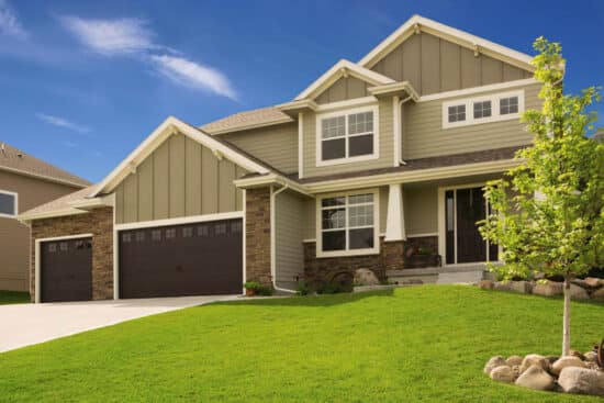 residential home with two faux wood grain style, sonoma/sonoma ranch panel garage doors