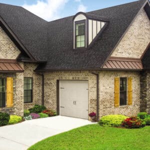 large multi-colored brick home with one carriage style, sonoma/sonoma ranch panel residential garage door