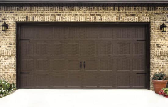 closeup of a large brown carriage style, sonoma/sonoma ranch panel residential garage door