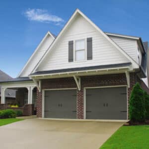 red brick home with two grey carriage style, sonoma/sonoma ranch panel residential garage doors