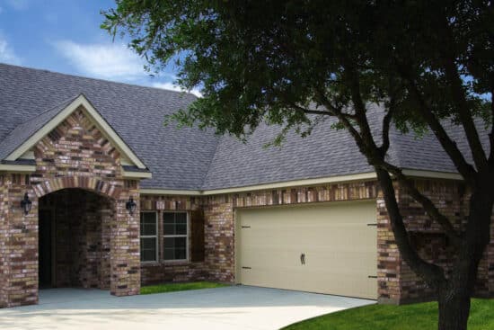 dark colored brick home in san antonio with a cream colored carriage style, sonoma/sonoma ranch panel residential garage door