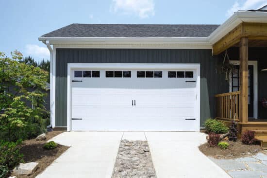 closeup of a san antonio home with a white carriage style, sonoma/sonoma ranch panel residential garage door