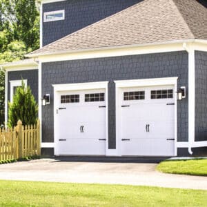 closeup of two white carriage style sonoma/sonoma ranch panel garage doors with windows on the top row on a san antonio home