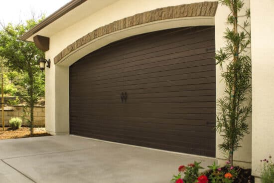 closeup of a dark walnut colored wayne-dalton 9800, faux wood grain style, fiberglass residential garage door