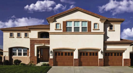 very large home with three vertical panel honduran mahogany colored wayne-dalton 9800, faux wood grain style, fiberglass residential garage doors