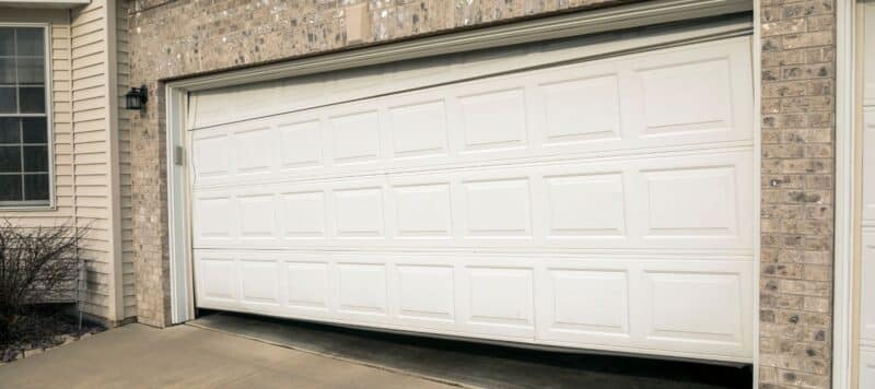 closeup of a white residential garage door that is in the process of opening