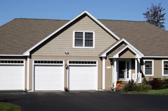 Home with three car white garage and new driveway