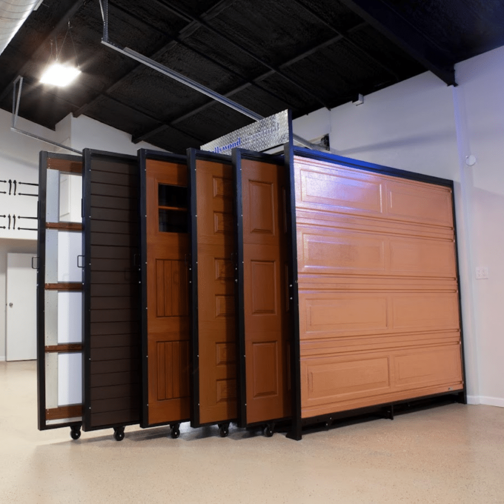 A lineup of full-sized wooden and metal garage doors on rolling display stands in a spacious showroom